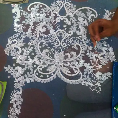White floral Aari placement embroidery being created by hand